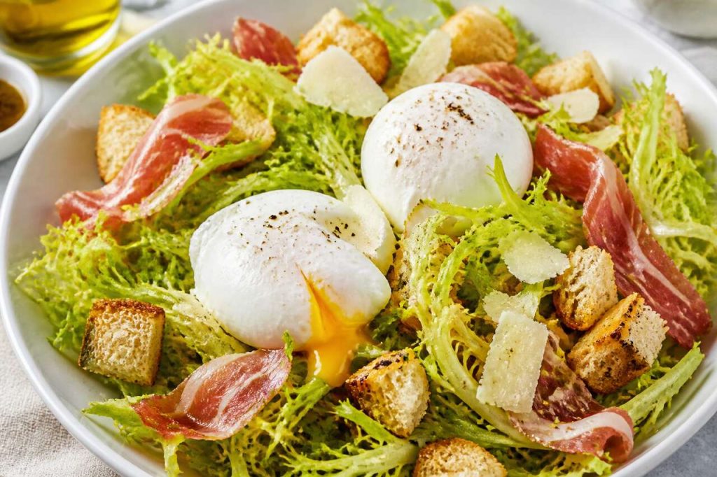 Recette de salade frisée : fromage, croûtons, pancetta et œufs pochés